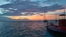 foto van ondergaande zon bij Bonaire met op voorgrond zeilschepen